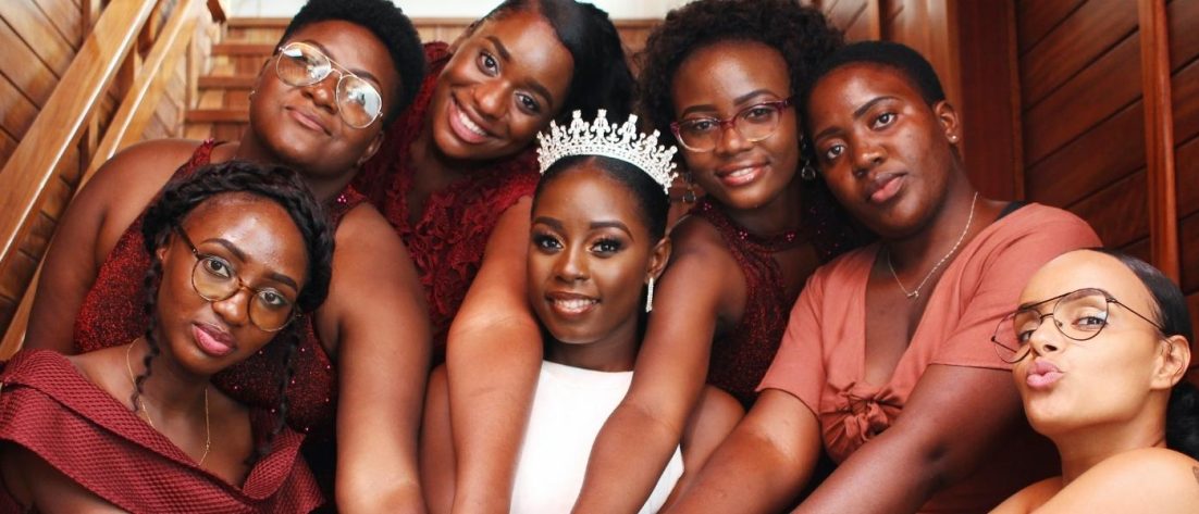 A group of Black bridesmaids surrounding their friend and bride-to-be.
