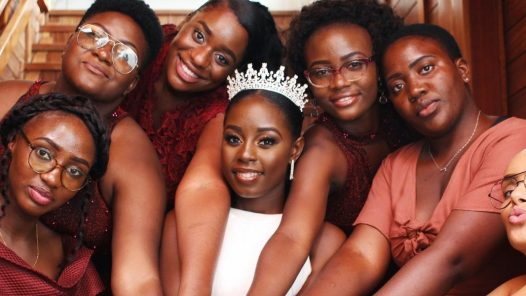 A group of Black bridesmaids surrounding their friend and bride-to-be.