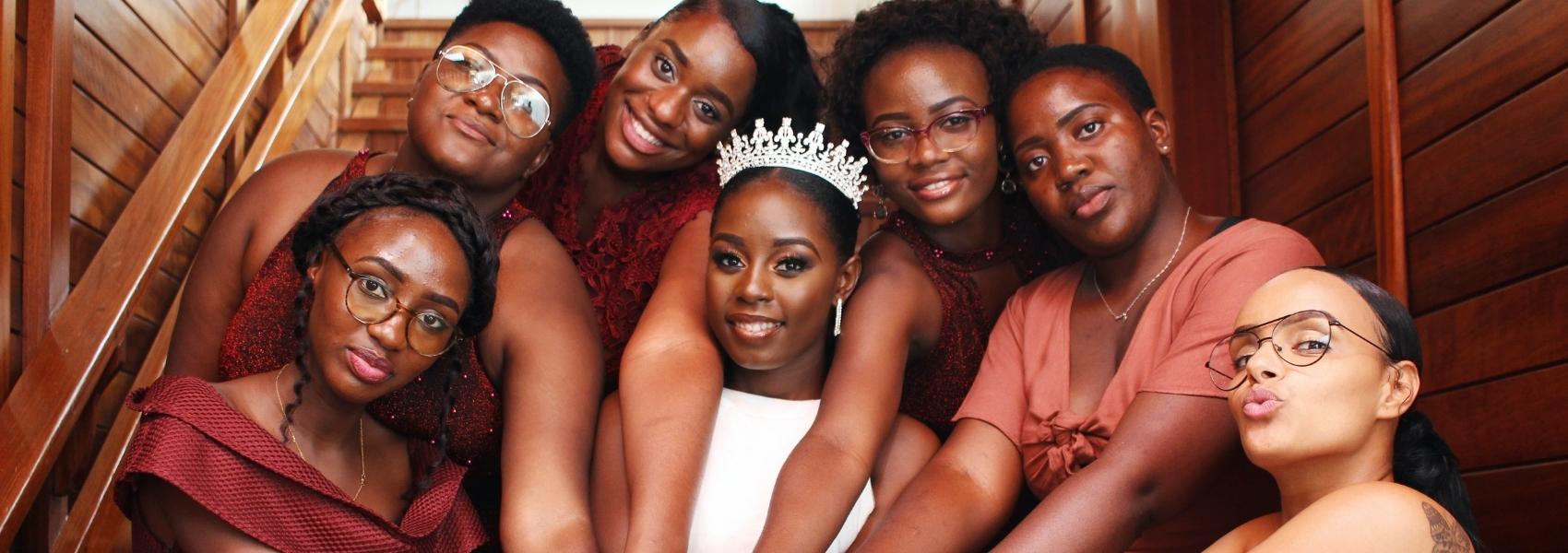 A group of Black bridesmaids surrounding their friend and bride-to-be.