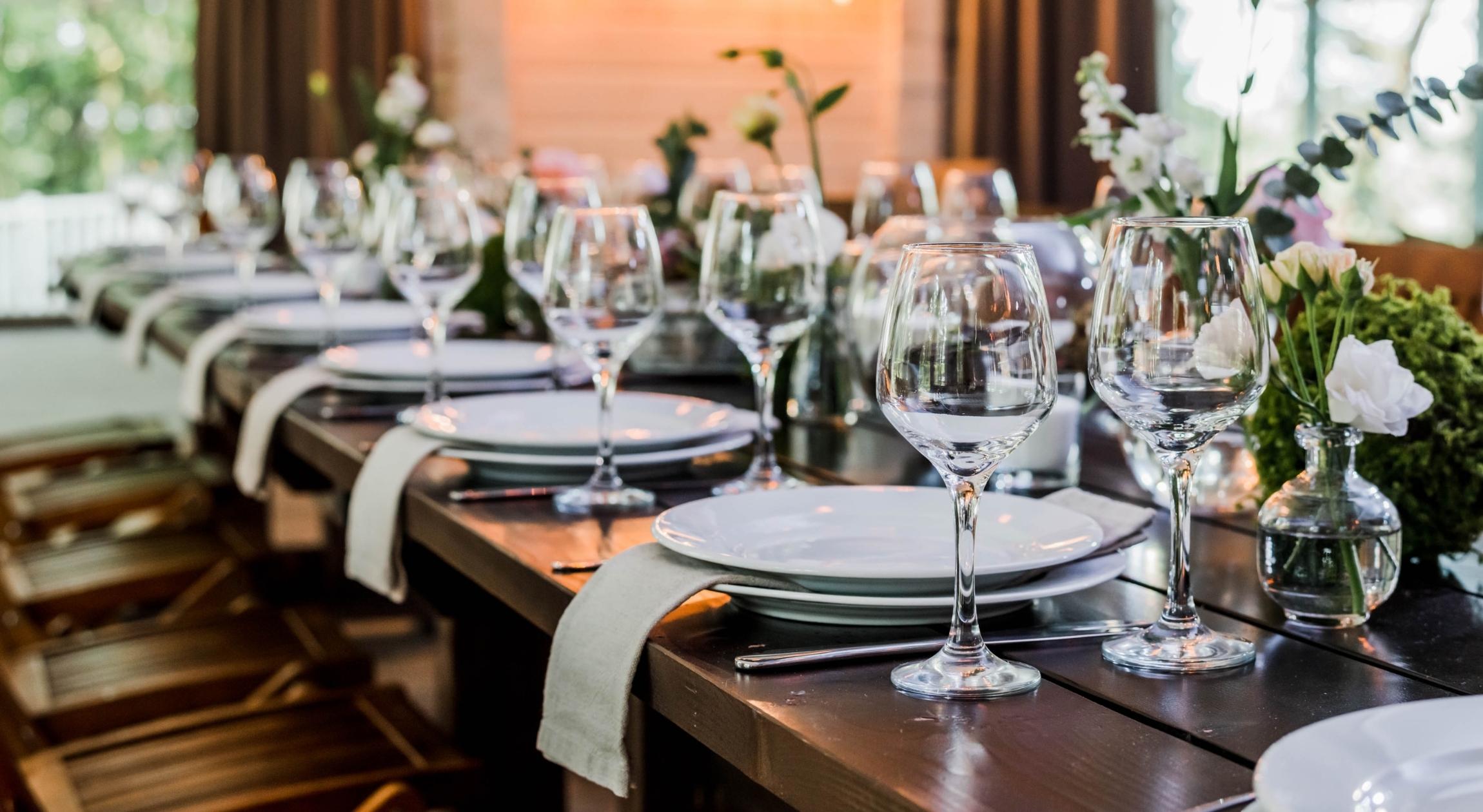 Table decorated with plates, chargers, goblets, and napkins