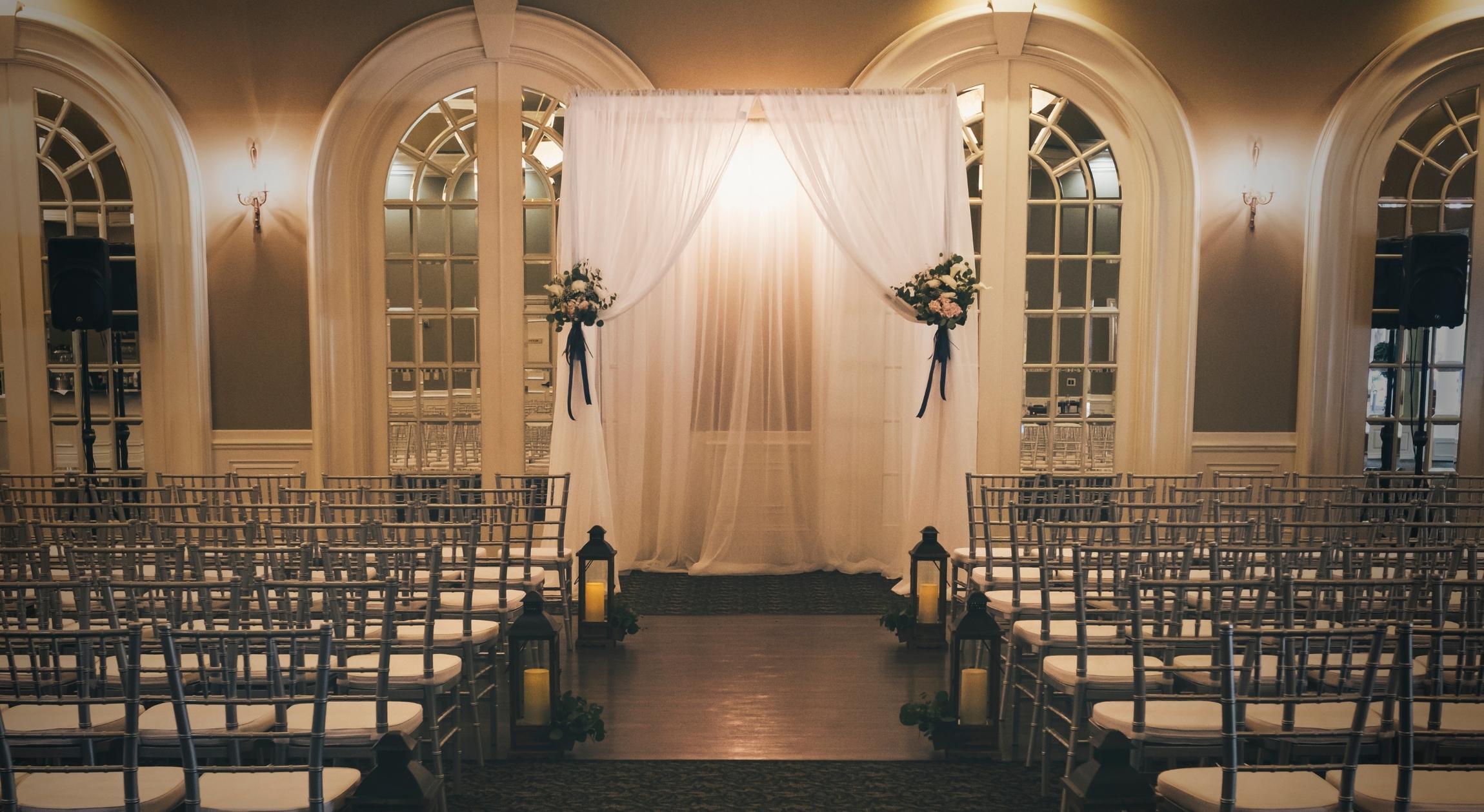 A low lit room with chairs and lights and a draped altar in the center