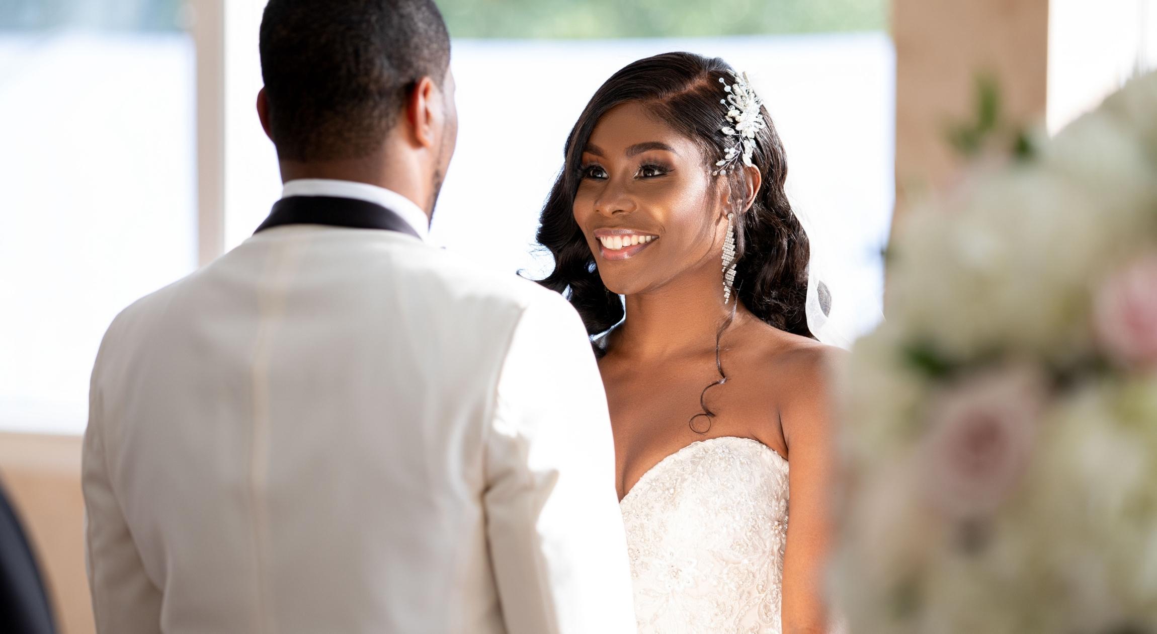 An African American bride stares and smiles at her groom