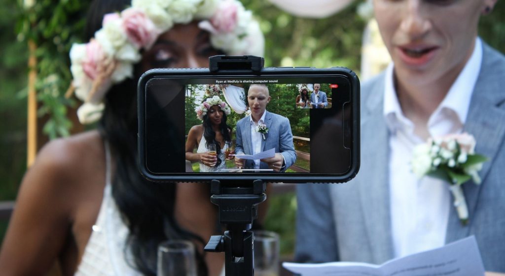 A phone streaming a wedding of a Black bride and a white groom