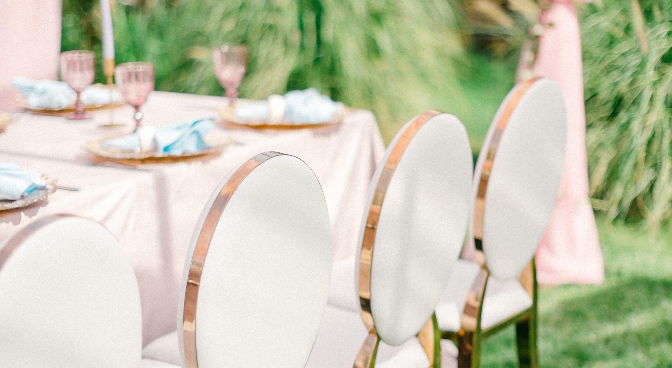 White chairs with a gold trim seated outside