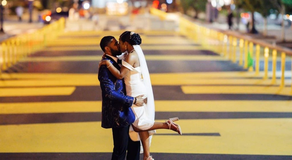 A Black couple kissing in the middle of the street