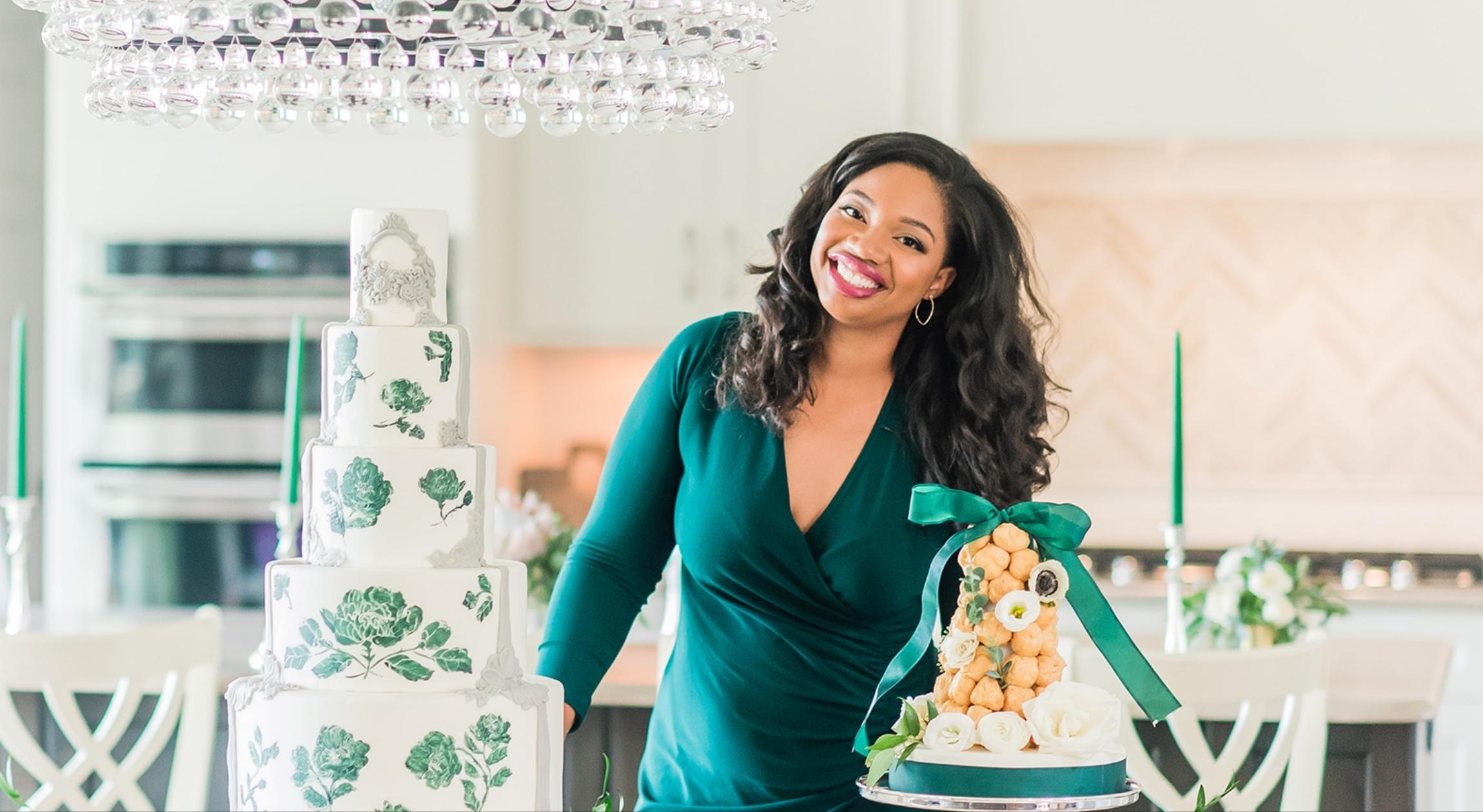 A Black woman in a green dress next to a wedding cake