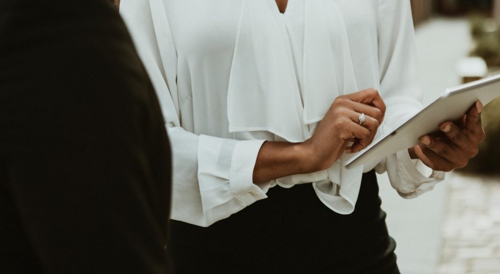 Hands of a Black woman holding a digital tablet