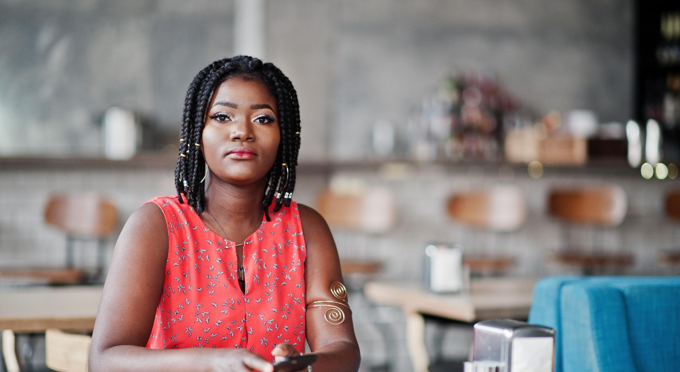 A Black woman with braids stares unamusingly