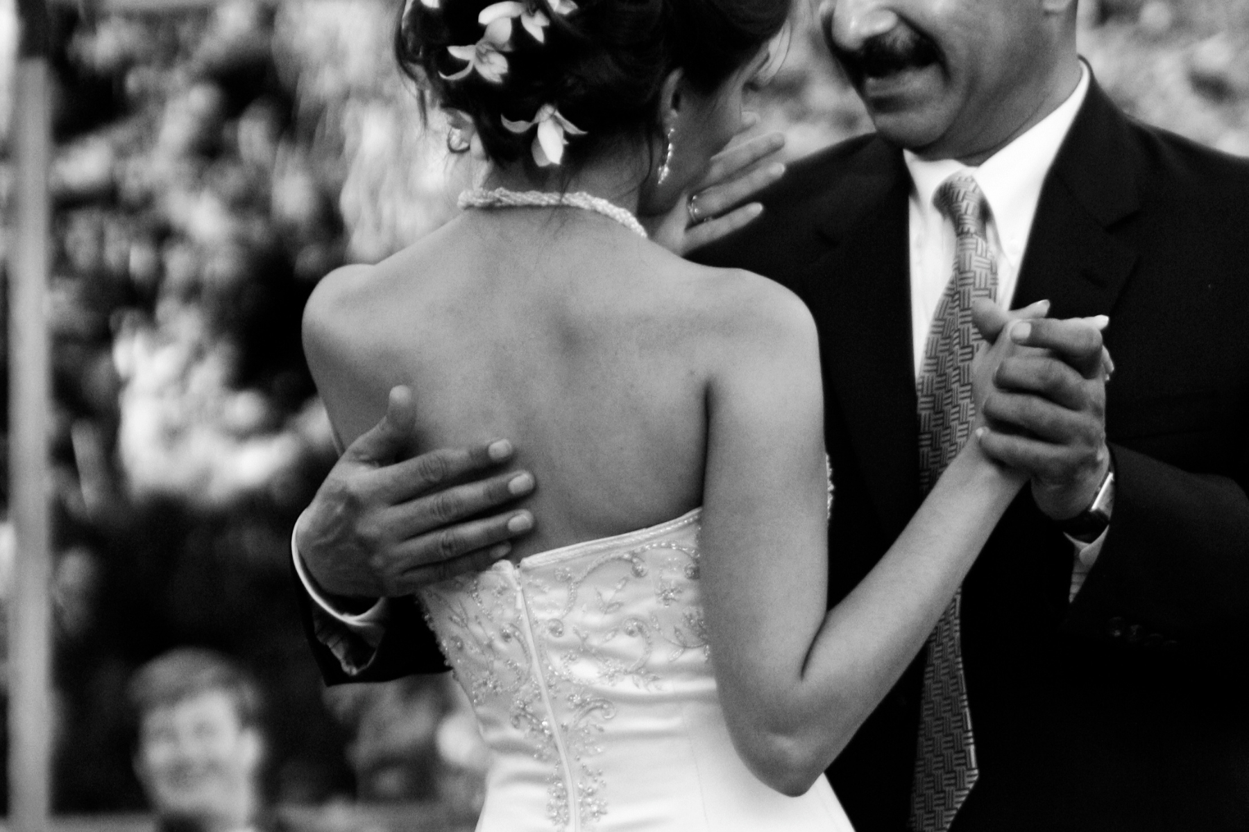 Black and white photo of the back of a woman dancing with an older man