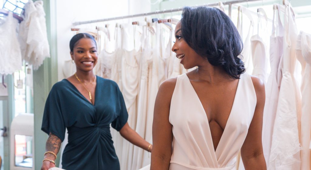 two people looking at dresses in a bridal shop