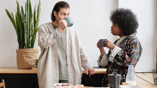 Two people drinking coffee in a kitchen