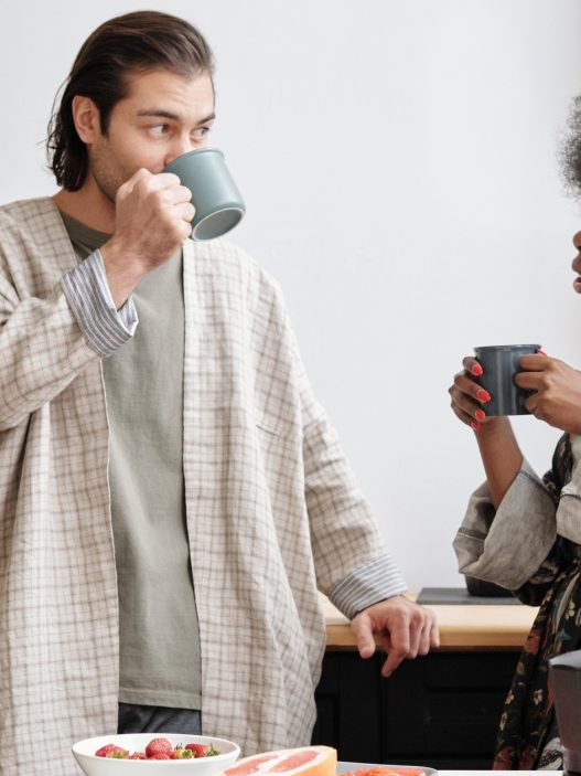 Two people drinking coffee in a kitchen