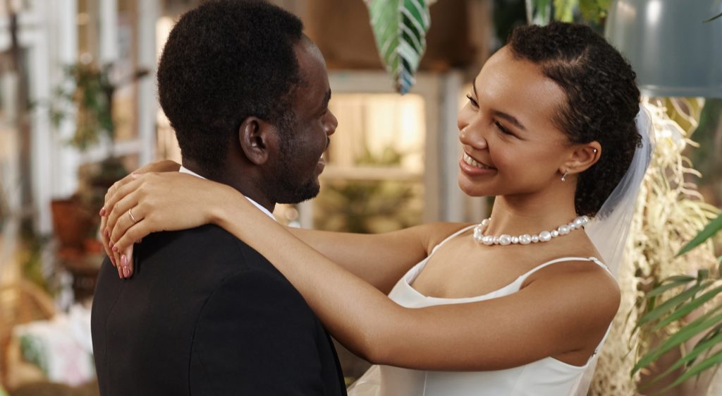 A person in a wedding dress hugging another person.