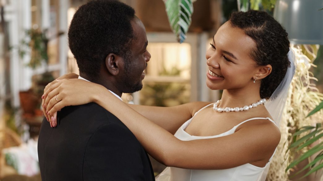 A person in a wedding dress hugging another person.