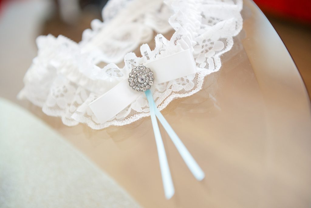 a lace garter with a blue ribbon on it