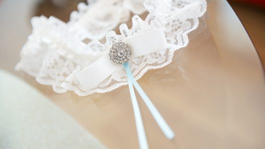 a lace garter with a blue ribbon on it