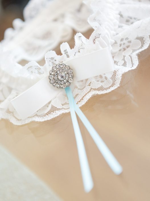 a lace garter with a blue ribbon on it