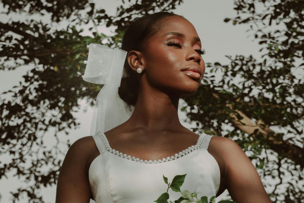 A woman in a white wedding dress holding a bouquet of flowers