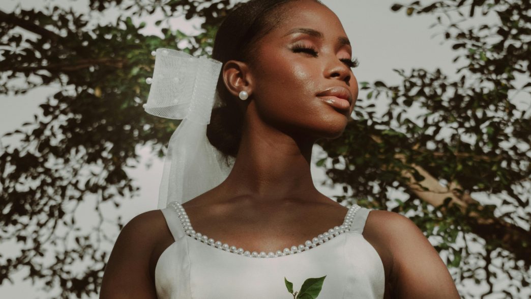 A woman in a white wedding dress holding a bouquet of flowers