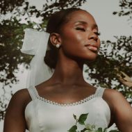 A woman in a white wedding dress holding a bouquet of flowers