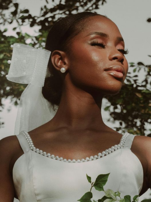 A woman in a white wedding dress holding a bouquet of flowers