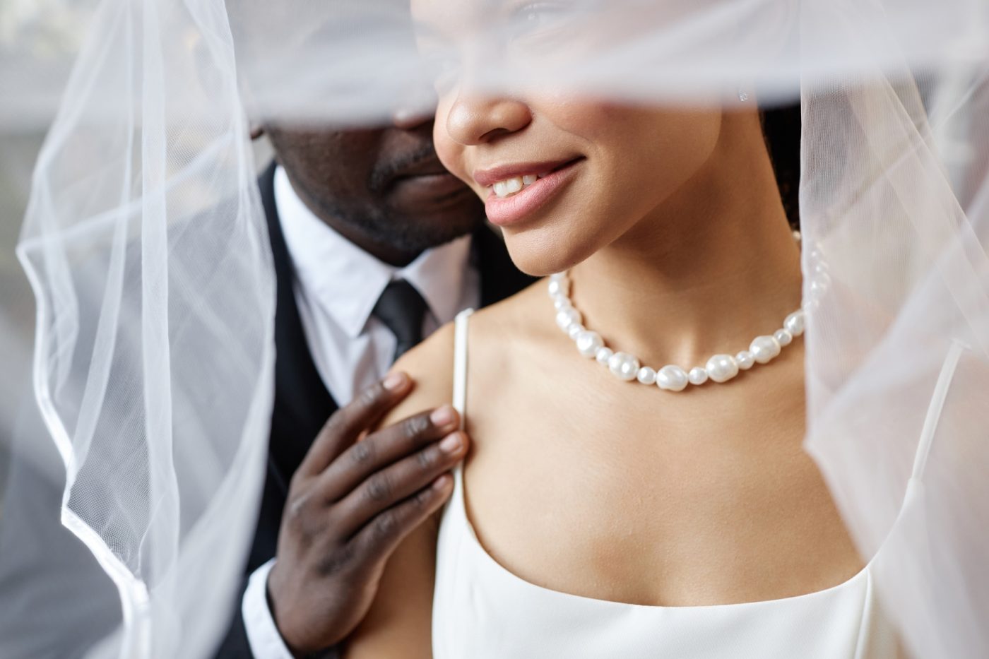 A man and woman embrace under a veil