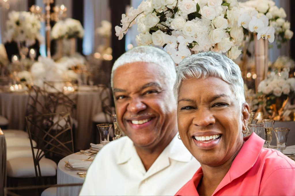 Older Black couple sitting at a wedding reception