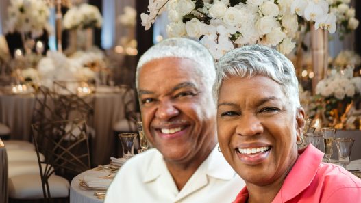 Older Black couple sitting at a wedding reception