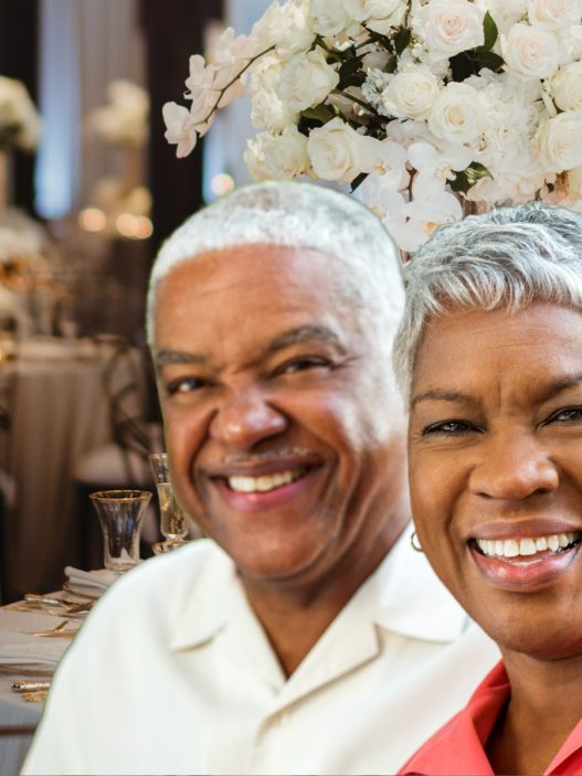 Older Black couple sitting at a wedding reception