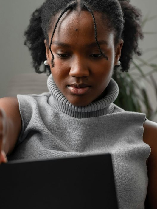 A person sitting on a couch looking at their laptop.