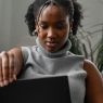 A person sitting on a couch looking at their laptop.