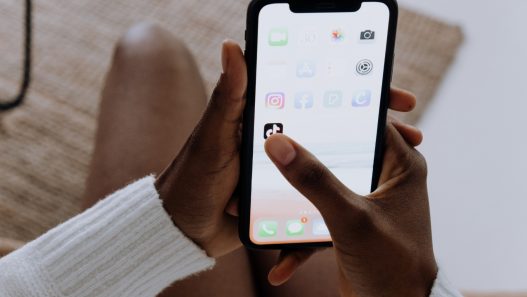 a person holding an iphone while sitting on a couch