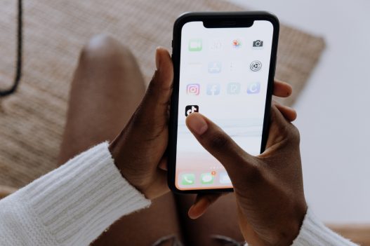 a person holding an iphone while sitting on a couch
