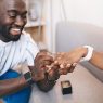 A person is putting a ring on their partner's finger.