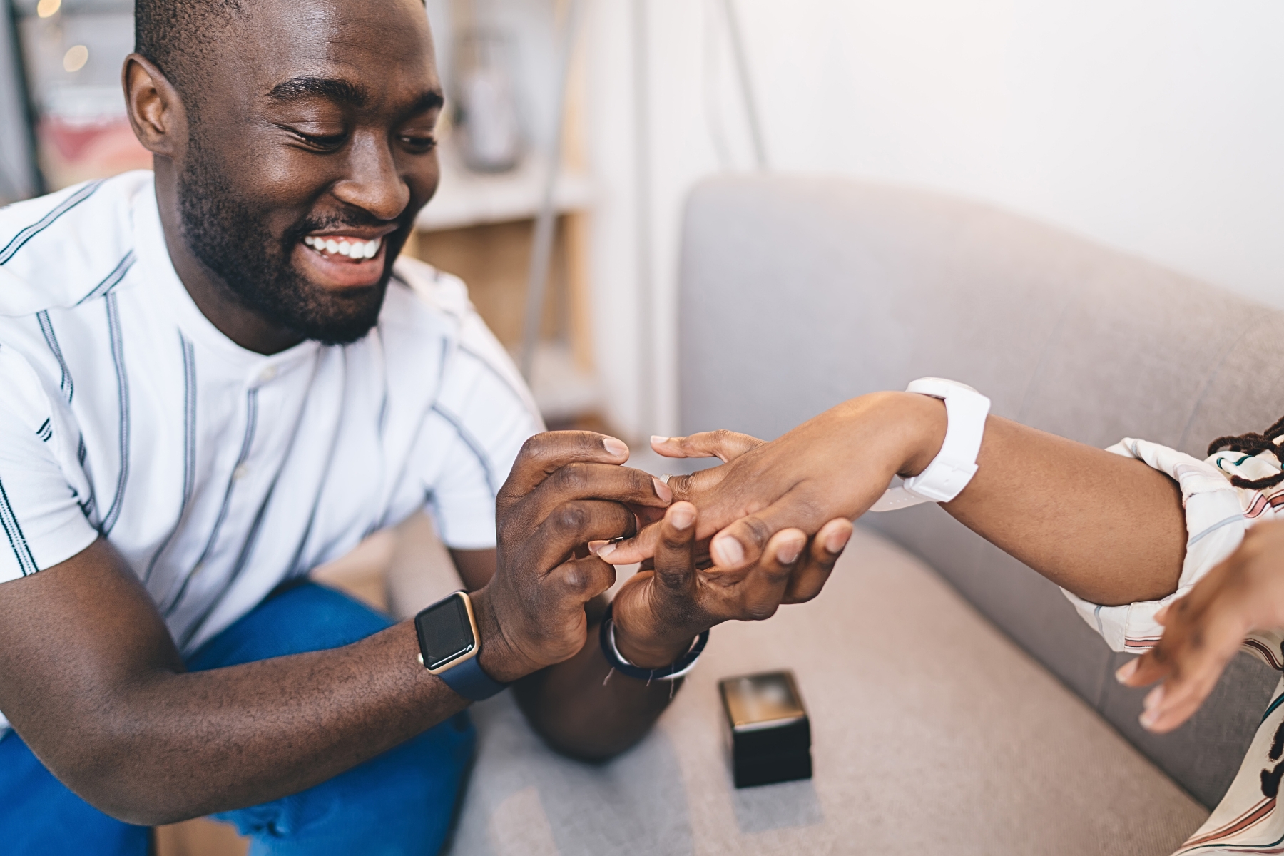 A person is putting a ring on their partner's finger.