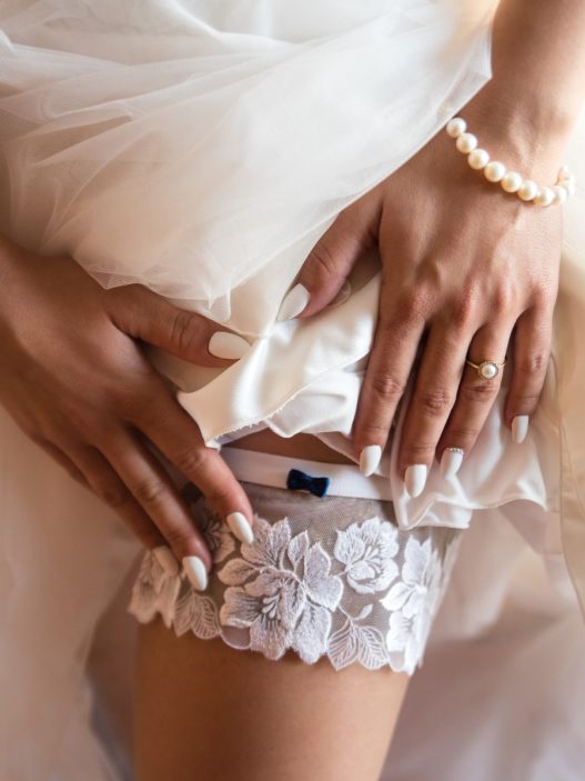 A person in a wedding dress is holding a wedding garter.