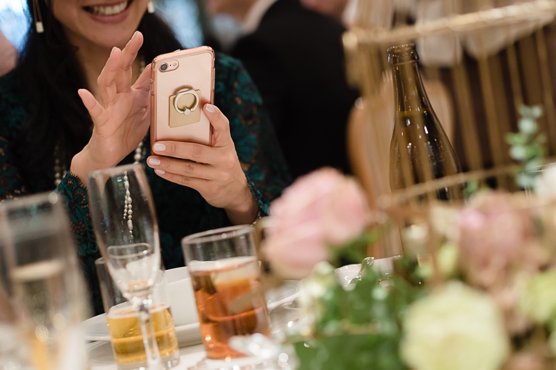 A wedding content creator taking a selfie with a cell phone at a wedding reception.