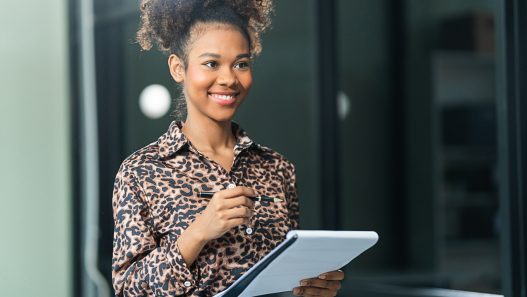 a smiling wedding planner holding a clipboard and looking at the camera