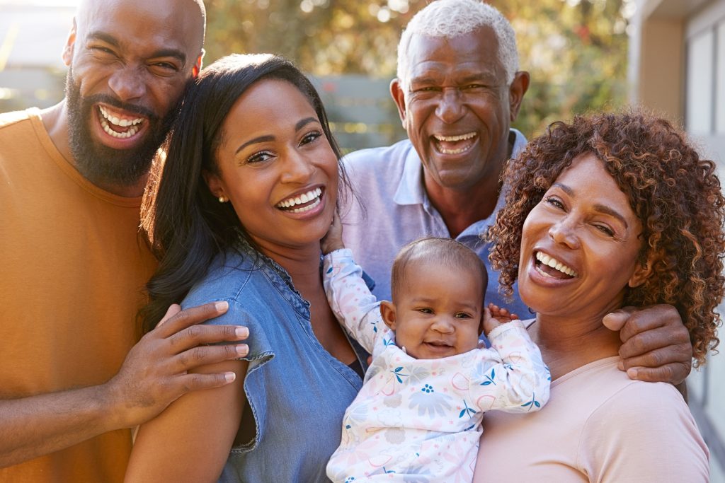 A Black family is smiling and posing for the camera.