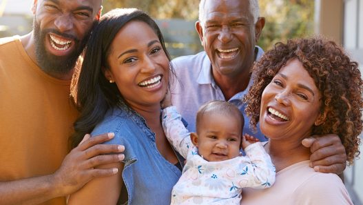 A Black family is smiling and posing for the camera.