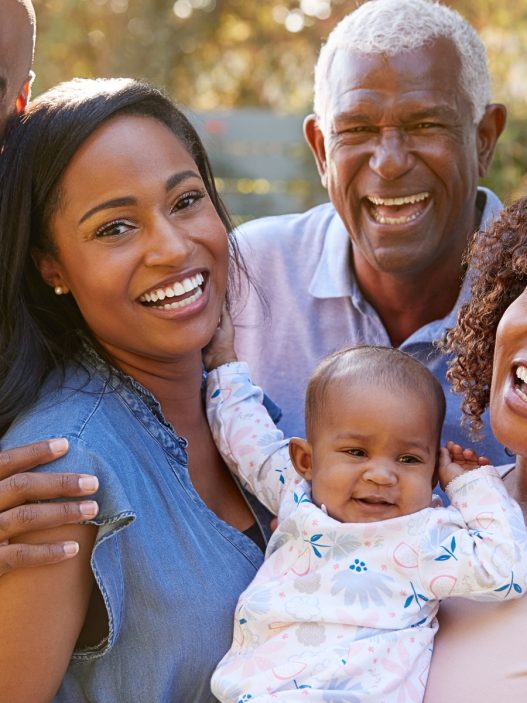 A Black family is smiling and posing for the camera.
