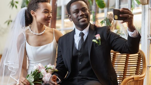 A Black couple taking a selfie at their wedding.