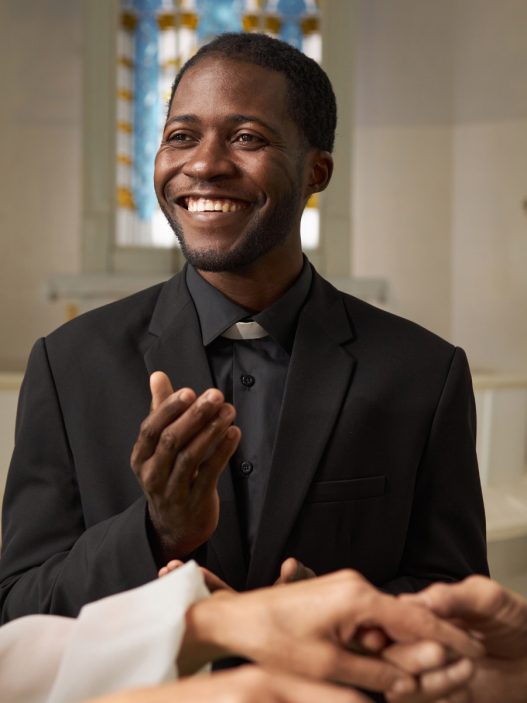 A wedding officiant stares at the couple with a smile during the ceremony