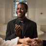 A wedding officiant stares at the couple with a smile during the ceremony