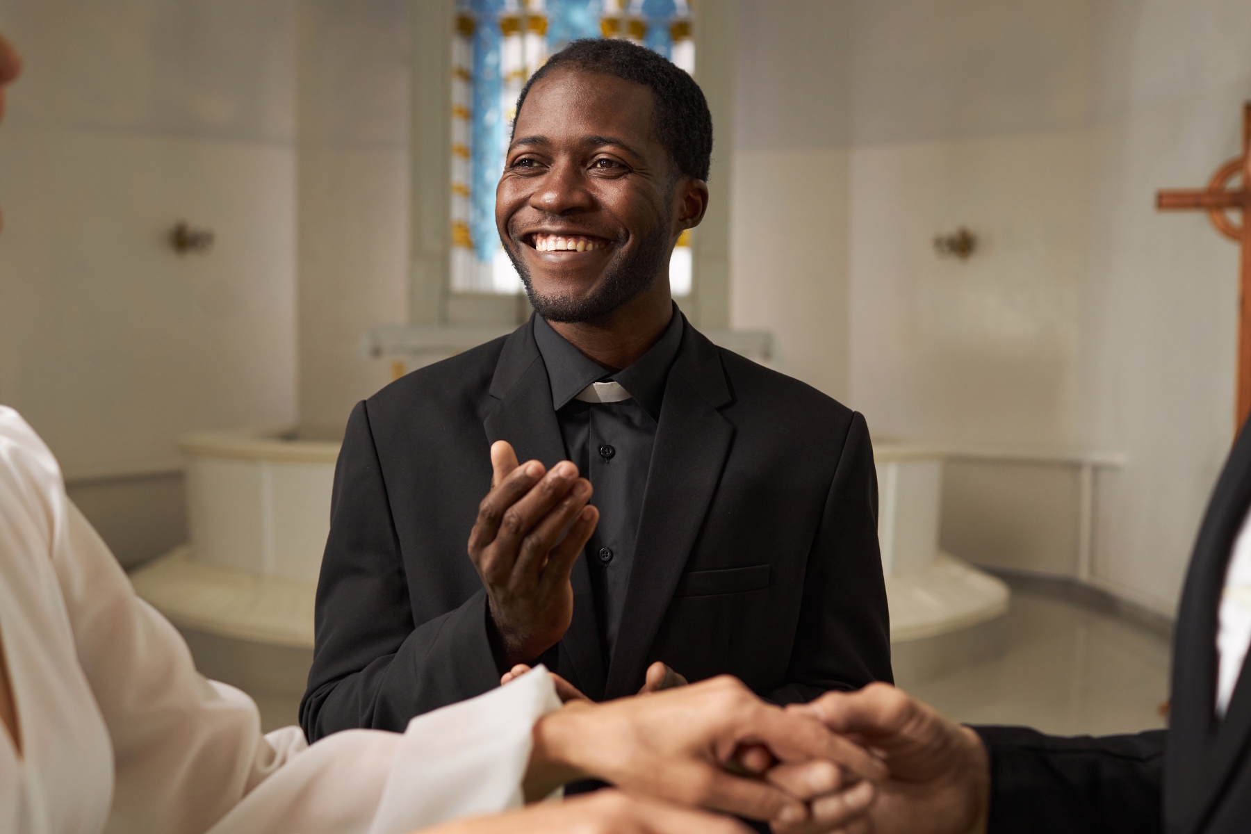 A wedding officiant stares at the couple with a smile during the ceremony