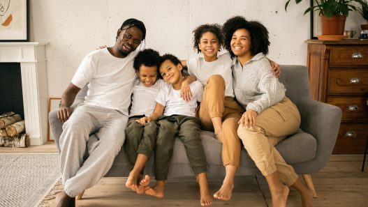 A family sitting on a couch in their living room