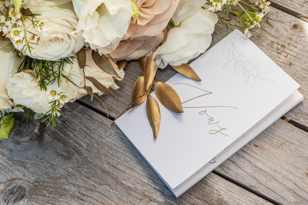 wedding cards and bouquet on a wooden table