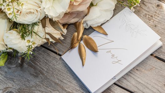 wedding cards and bouquet on a wooden table