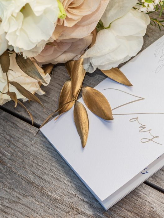 wedding cards and bouquet on a wooden table