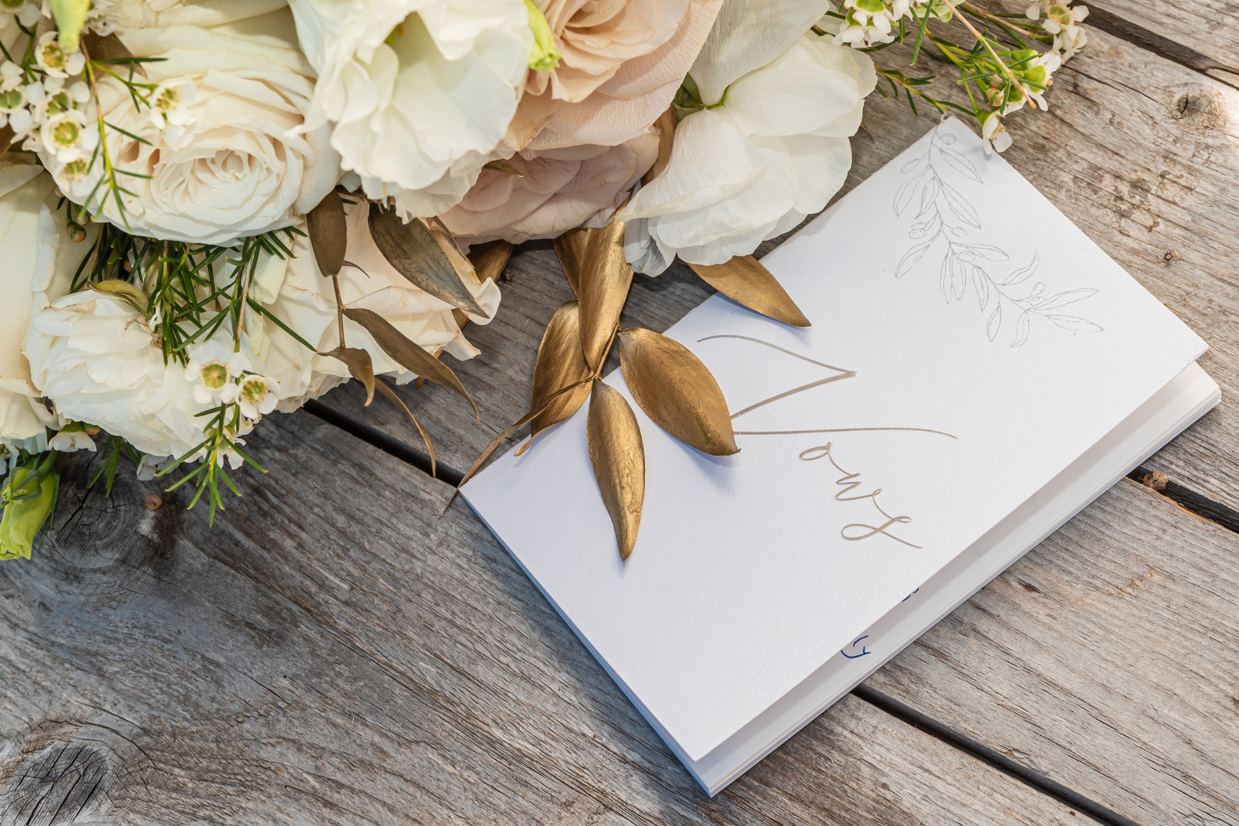 wedding cards and bouquet on a wooden table